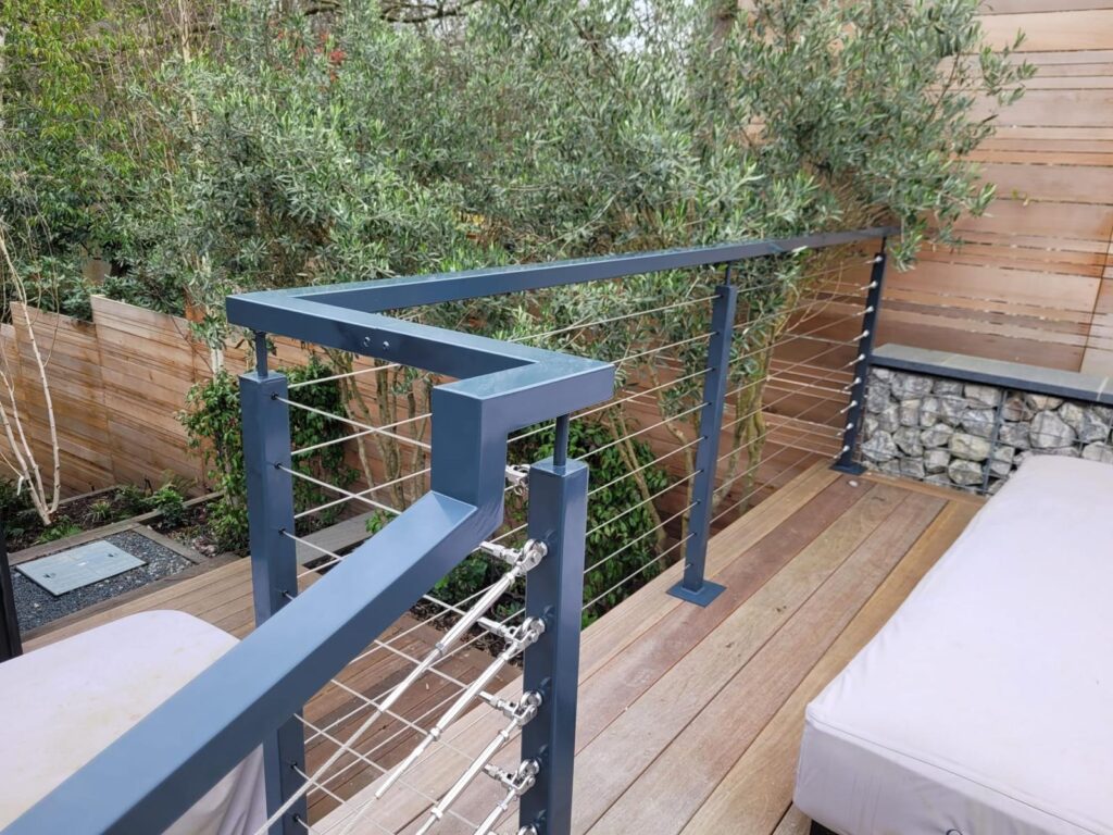 WhatsApp Image 2024-03-22 at 11.19.03_206bd432 Close-up view of a modern post and wire balustrade system with sleek metal posts and cables, installed on a wooden deck, enhancing safety and adding a contemporary touch to the outdoor area.