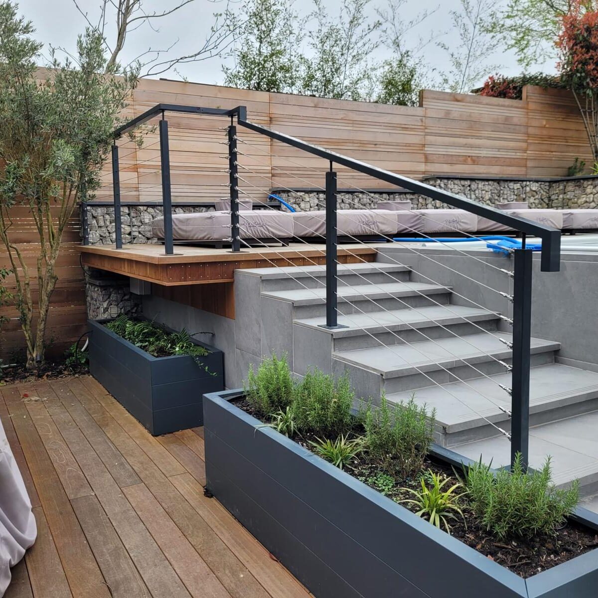 Wire Balustrade Systems 2 Modern outdoor deck featuring a post and wire balustrade system with sleek metal posts and cables, enhancing the contemporary design of the multi-level terrace and providing safety and style.