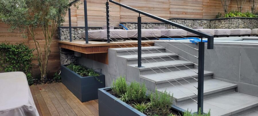 WhatsApp Image 2024-03-22 at 11.19.03_da573479 Modern outdoor deck featuring a post and wire balustrade system with sleek metal posts and cables, enhancing the contemporary design of the multi-level terrace and providing safety and style.