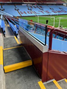 Aston Villa Football Ground: Enhancing Safety and Visibility 1 Installation of 25.5mm laminate glass and track system at Aston Villa Football Ground, providing a clear, secure barrier between the stands and the pitch.