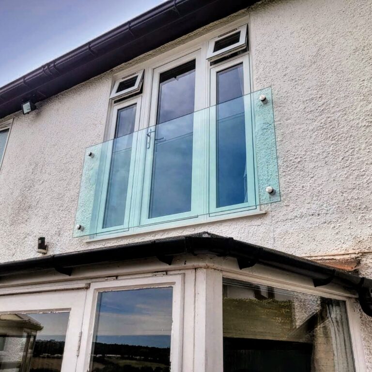 IMG-20240813-WA0010~2 ide view of the frameless Juliet balcony on a modern home in Wolverhampton, highlighting the minimalistic design and secure glass adaptors.