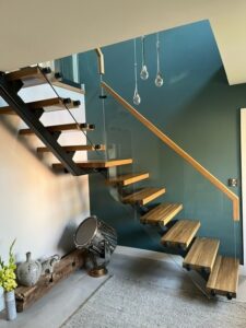 staircase Modern floating glass steel staircase with single spine steel structure, oak timber treads, and seamless glass balustrades, creating a minimalist yet striking focal point in a contemporary home.