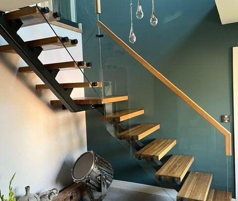 staircase Modern floating glass steel staircase with single spine steel structure, oak timber treads, and seamless glass balustrades, creating a minimalist yet striking focal point in a contemporary home.