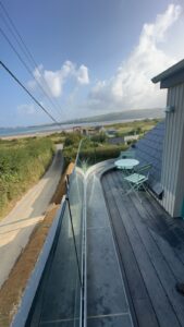 Curved and straight glass balustrade installation overlooking the sea.