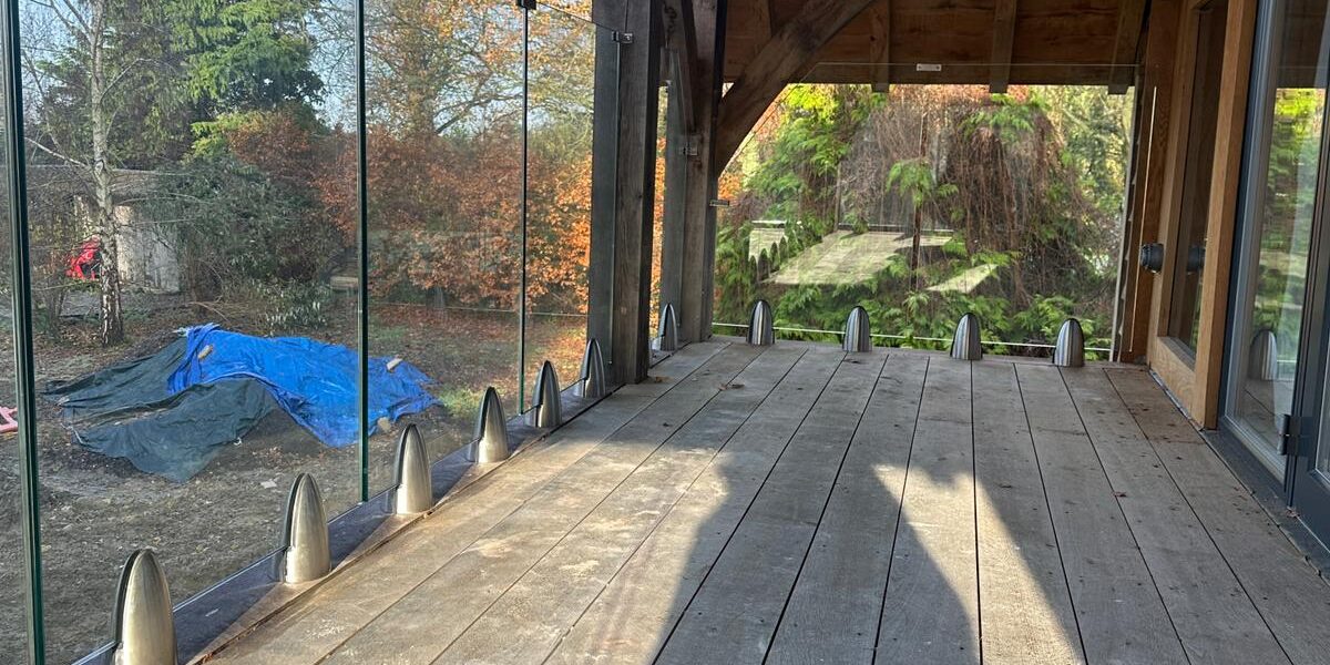 Frameless glass balustrade on a wooden deck in Oxford, showcasing a modern and secure installation.
