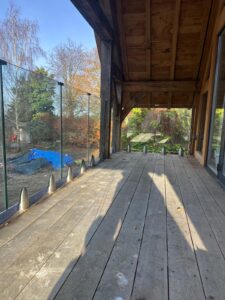 Frameless glass balustrade on a wooden deck in Oxford, showcasing a modern and secure installation.