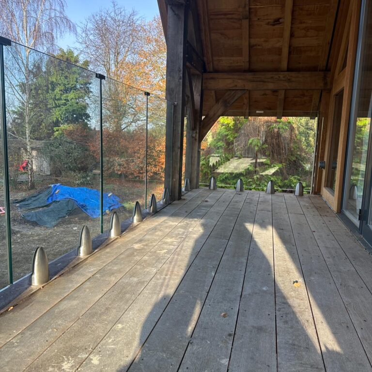 WhatsApp Image 2024-11-21 at 11.42.30_a66796e4 Frameless glass balustrade on a wooden deck in Oxford, showcasing a modern and secure installation.