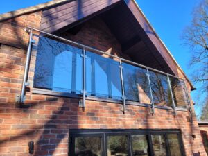 Full view of a contemporary glass balustrade on a raised balcony, blending seamlessly with the home's design.