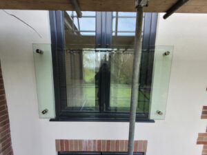 Side view of a Frameless Boss Juliet Balcony showcasing the secure stainless steel standoff fixings and seamless glass design