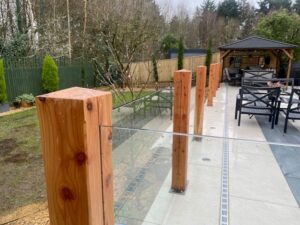 Side view of a handrail-free glass balustrade with timber posts.