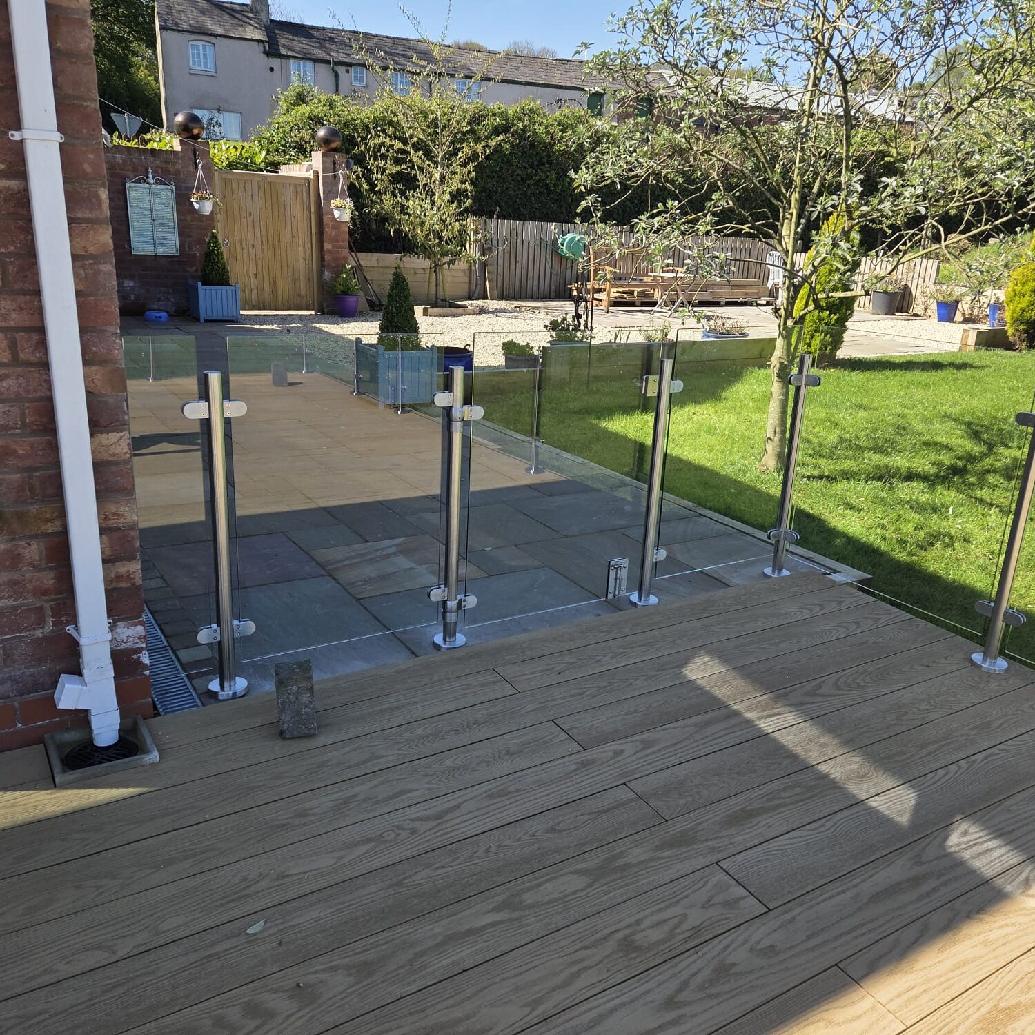 Modern garden decking fitted with clear glass balustrades