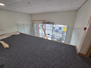 frameless glass balustrade on mezzanine in building firm office