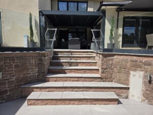 terrace steps with frameless glass balustrade and wall-mounted stainless steel handrails