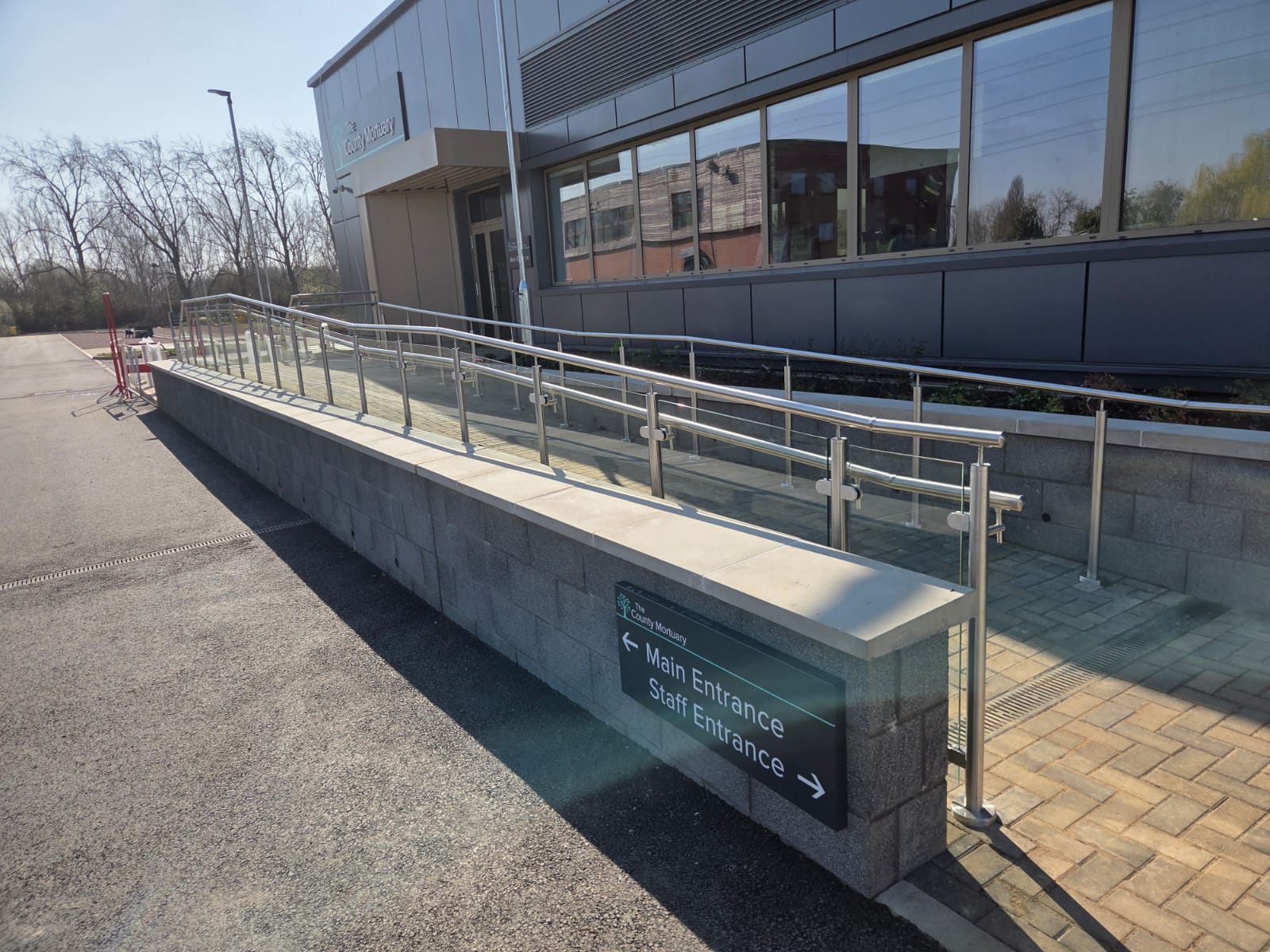 Glass balustrade ramp at mortuary in Northampton with stainless steel posts, handrail and 10mm toughened glass panels