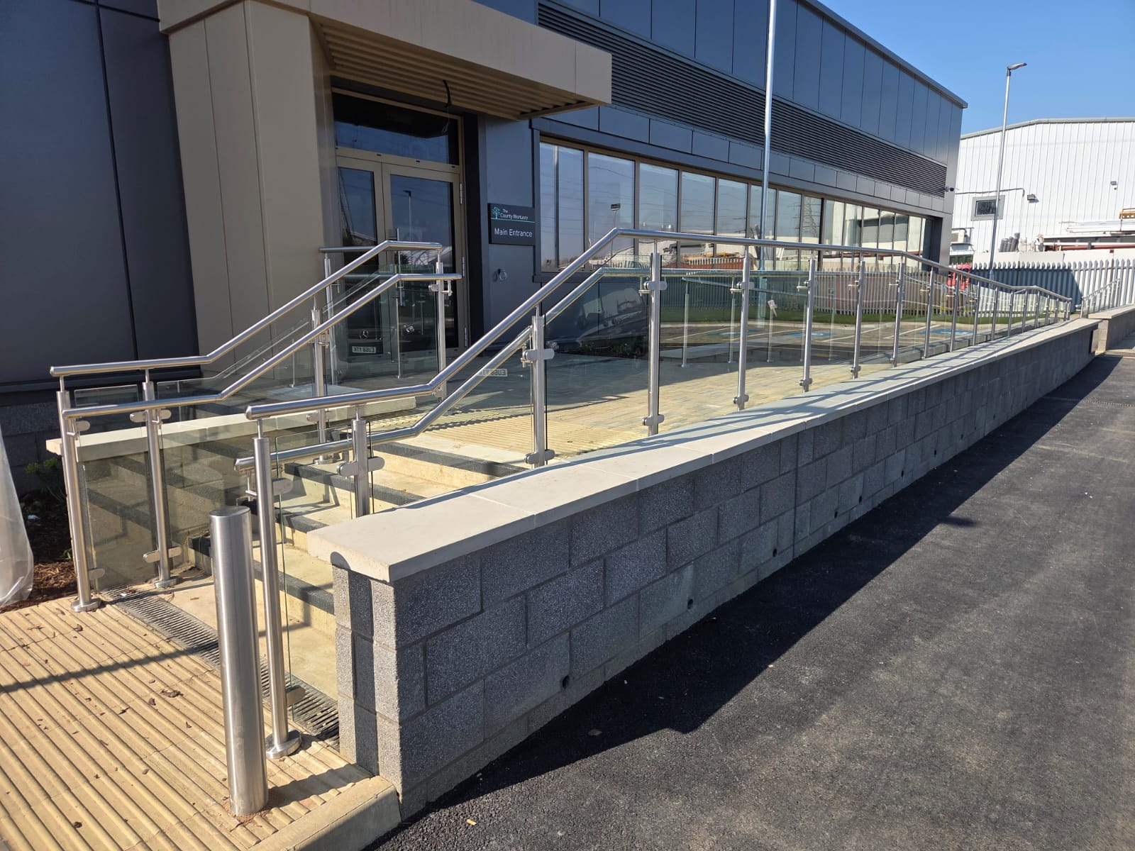Glass balustrade with integrated handrail and steps at commercial mortuary entrance in Northampton